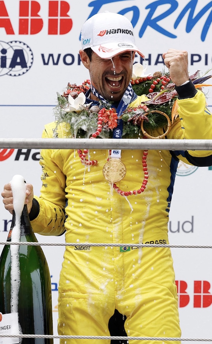 Lucas celebrating on the podium in his yellow racing suit