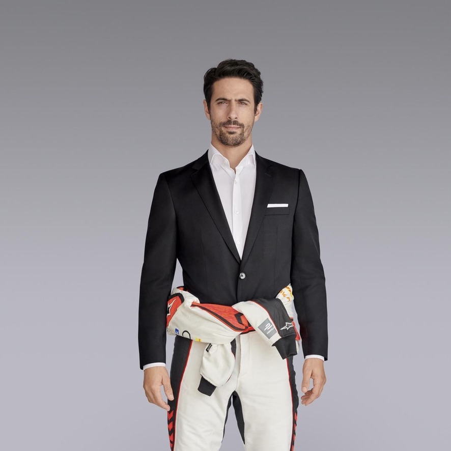 Lucas di Grassi wearing a business suit over his racing overalls
